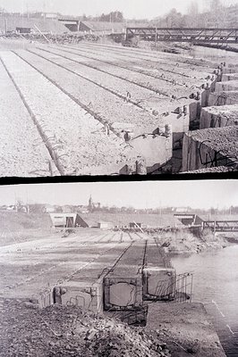 Overhead view of a railway line construction site, featuring large concrete blocks and unfinished track. Shows extensive exca...