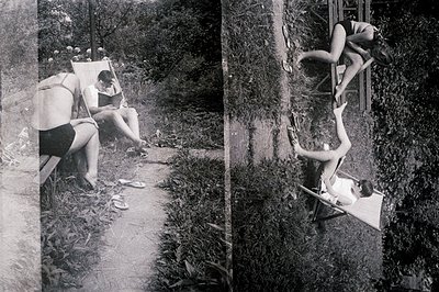 Split-tone black and white photograph. A young woman lounges in a garden chair, reading, while another playfully jumps over h...