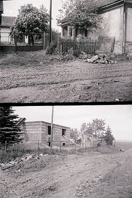 A partial, unfinished brick building sits alongside a weathered wooden fence and a traditional house, both appearing abandone...