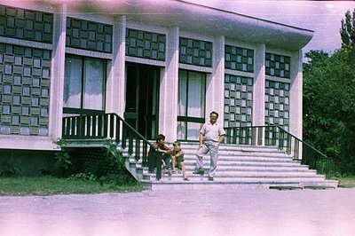 Exterior view of a modernist building with a prominent staircase, likely a public or cultural institution. A man and child de...