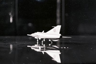 Black and white photograph shows a detailed model of a supersonic jet, likely a Douglas DC-8, with Japanese markings visible....