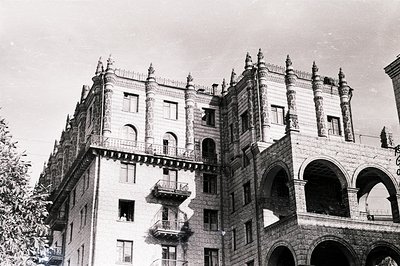 Ornate, multi-story building exhibiting Gothic Revival architecture. Arched loggia creates a dramatic facade. Likely a luxury...