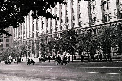Grand Beaux-Arts architecture dominates the scene, featuring a monumental facade with arched windows and intricate detailing....