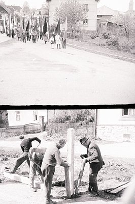 A group of men appear to be erecting a monument or stone structure in a residential area. They are using shovels and ropes to...
