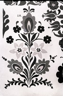 Detailed floral motif in black on white. Stylized foliage and blooms exhibit traditional design elements. Likely a textile or...