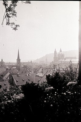Panoramic view of Prague, Czech Republic. A cityscape of tightly packed, red-tiled roofs ascends towards a prominent skyline ...