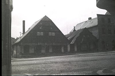 A view of traditional buildings with steeply pitched, slate roofs and brick chimneys. Likely a residential or commercial area...