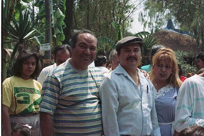 A portrait shows a family amidst lush foliage, possibly a tropical garden or tourist attraction. The group includes a young g...