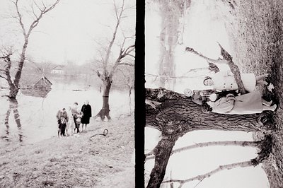 A vintage black & white photograph depicts a family group alongside a small aircraft embedded in a tree. The scene suggests a...