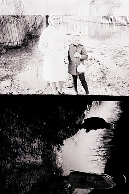 Two figures, a woman in a long coat and a child in a winter coat, stand in a muddy, snow-dusted yard, appearing solemn and co...