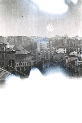 An architectural cityscape, likely European, viewed from an elevated position. Buildings with tiled roofs and varied architec...