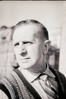 Striking portrait of a man in a patterned vest, shirt, and tie, gazing slightly off-camera. Sharp focus on facial features an...