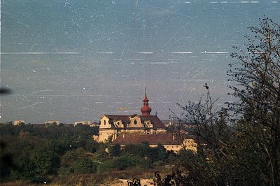 A stately building with a central dome and ornate roofline dominates this view, likely a historical manor or estate. Situated...