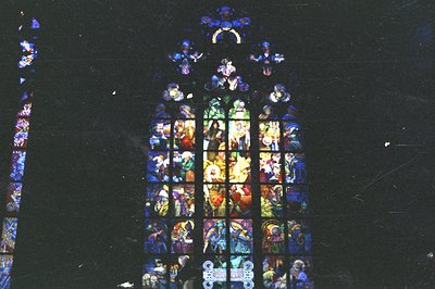 Stained glass window depicting biblical scenes, characterized by vibrant colors – blues, reds, and yellows – arranged in a ta...