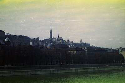 A view of Salzburg, Austria, featuring the Salzburg Cathedral and Residenz Palace. Buildings line the riverbank, showcasing v...