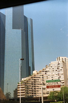 View of La Défense business district in Paris, France. Modern architecture includes a towering glass skyscraper and a large, ...