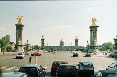 Framed by imposing columns topped with gilded statues, this view captures the Place de la Concorde, Paris. A wide avenue lead...