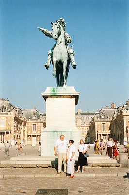 Monumental equestrian statue of Louis XIV dominates the Place d’Hercule, Paris. Tourists pose in foreground, showcasing the o...