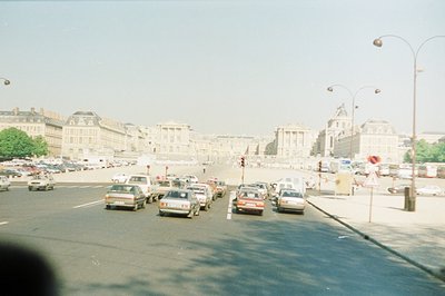 View of the Place de la Concorde, Paris, France. Heavy traffic dominates the wide avenue, featuring classic 1970s-80s Europea...