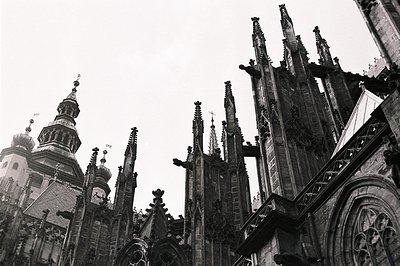 Dramatic, high-angle view of Gothic cathedral architecture. Intricate spires and detailed stonework dominate the skyline. Lik...