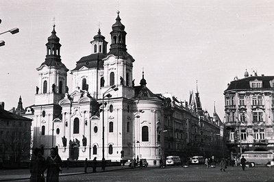 Classic baroque architecture dominates this view. The church’s facade features paired columns, oval windows, and twin towers....