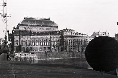 Grand, ornate opera house architecture showcases a domed roof & elaborate detailing. A tiered facade rises above a retaining ...