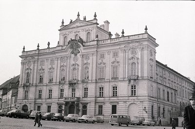 Grand, ornate Baroque palace with symmetrical facade, elaborate cartouche, and balustrade. Features multiple windows, promine...