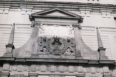 Architectural detail of a building facade displaying a coat of arms and inscription: “DMATHIASEL. ROM. IMP. S. AVG. HVNG. BOH...