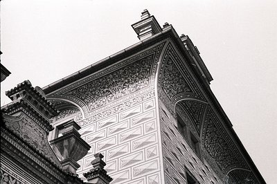 Ornate exterior detail showcasing intricate stucco work and architectural flourishes. Features a corbelled edge, diamond-patt...