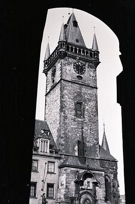 Tall, historic tower with visible clock faces framed within an archway. Stone ma...