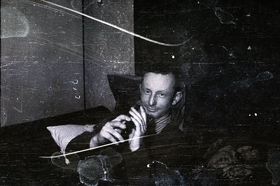 A portrait of a cellist performing in a dimly lit setting. The musician, mid-performance, has a focused expression. Visible a...