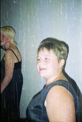 Close-up, slightly blurred color photograph shows a young person with short, dark hair and pale skin. They wear a dark sleeve...