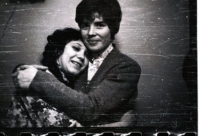 Two women embrace warmly in a candid portrait. The younger woman leans into the embrace, while the older woman has an arm aro...