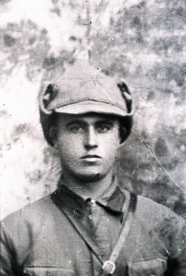 Close-up, monochrome portrait of a young man wearing a military cap and uniform, likely a soldier. He appears serious, lookin...