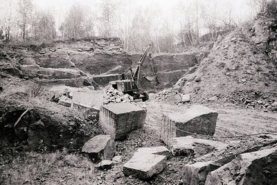 Extensive quarry operation showing large stone blocks being extracted. Visible machinery suggests mechanized extraction; like...