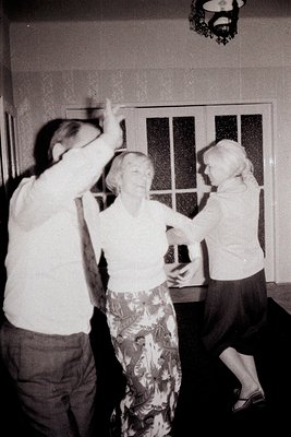 A joyful scene captures a dance between a man and a woman, likely a social gathering or celebration. The man, with raised arm...