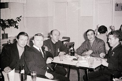 Group portrait around a table, likely a social gathering. Five men in formal attire, some with military insignia visible. Sim...