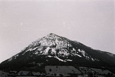 Striking landscape photo of a sharply-peaked mountain, likely limestone, with visible erosion and some snow patches near the ...