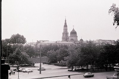 Overlooking a plaza, a monumental cathedral dominates the skyline. Classicist architecture with a central spire & rounded dom...