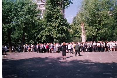 Large outdoor gathering of uniformed individuals in a tree-lined plaza, likely a 1960s–1980s Soviet-era event. Formal attire ...