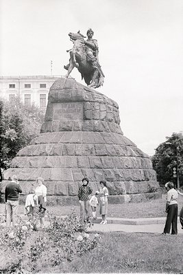 Equestrian statue atop a stepped stone pedestal in an urban park, likely honoring a historical figure. Inscription on base re...