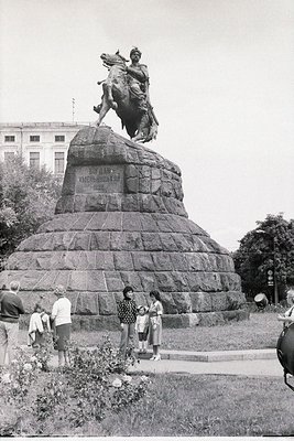Equestrian statue atop a stone pedestal with Cyrillic inscription, likely honoring a historical figure. Surrounding pedestria...