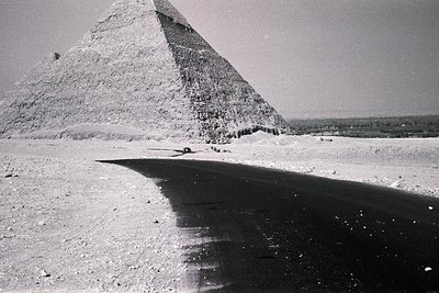 Classic black-and-white shot of the Great Pyramid of Giza, showcasing its iconic triangular silhouette and weathered limeston...