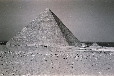 Black-and-white photograph of the Great Pyramid of Giza and Pyramid of Menkaure, showcasing their monumental scale and desert...