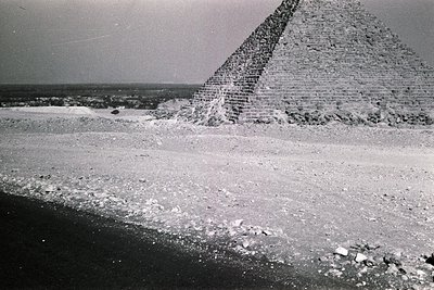 Vintage black-and-white shot of the Great Pyramid of Giza, showcasing its massive limestone structure and desert surroundings...