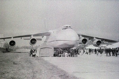 A vintage black-and-white photo of a **Tupolev Tu-114** (or similar Soviet-era airliner) on display, surrounded by a crowd. F...