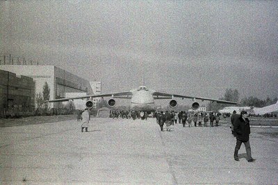 A vintage Tupolev Tu-114, a Soviet-era long-range airliner, dominates the scene with its distinctive four-engine turboprop se...