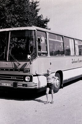 A young child stands beside a vintage **Zahnradbahn** (cogwheel railway) coach, likely from the **1960s–1970s**, in Switzerla...