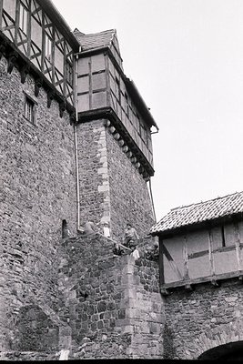 Medieval stone tower with timber-framed upper section, likely part of a castle or fortress. Stonework features rough-hewn blo...