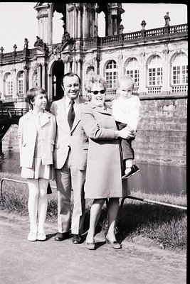 Family portrait in front of **Schönbrunn Palace, Vienna**, c. **1960s**. Four individuals pose on a gravel path near the pala...